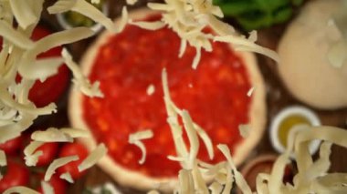 Pizza hamurunun üzerine, kamera takibi ve dönüşüyle rendelenmiş peynirin çok yavaş düşüşü. Yüksek hızlı sinema kamerası, 1000 fps..