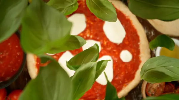 Super Zeitlupe Fallender Frischer Basilikumblätter Auf Pizzateig Mit Sugo Ansicht Stockfoto