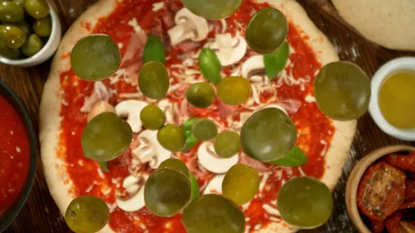 Super Zeitlupe Von Fallenden Verschiedenen Zutaten Auf Pizzateig Mit Sugo Stockbild