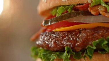 Lezzetli ev yapımı hamburger, kamera hareketi ve dönüşümlü. Lezzetli burger taze lahana, peynir, soğan, pastırma, domates ve ızgara biftek..