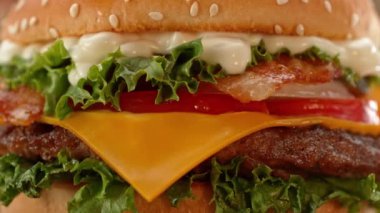 Lezzetli ev yapımı hamburger, kamera hareketi ve dönüşümlü. Lezzetli burger taze lahana, peynir, soğan, pastırma, domates ve ızgara biftek..
