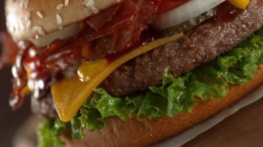 Lezzetli ev yapımı hamburger, kamera hareketi ve dönüşümlü. Lezzetli burger taze lahana, peynir, soğan, pastırma, domates ve ızgara biftek..