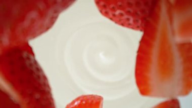 Yoğurt kremine dökülen çileklerin süper yavaş çekimleri. Hareketli ve dönüşlü yüksek hızlı sinema kamerası ile çekildi, 1000fps.