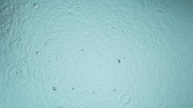 Freeze motion of splashing water drops on on light blue background clipart