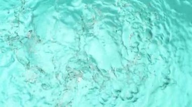 Açık mavi arkaplanda yavaş su sıçratma, yüksek hızlı sinematik kamera 1000 FPS