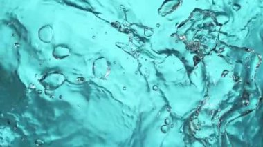 Açık mavi arkaplanda yavaş su sıçratma, yüksek hızlı sinematik kamera 1000 FPS