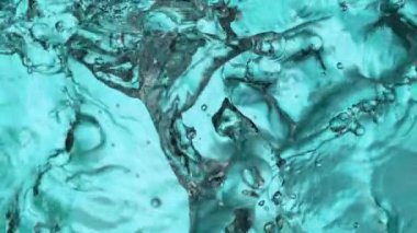 Açık mavi arkaplanda yavaş su sıçratma, yüksek hızlı sinematik kamera 1000 FPS