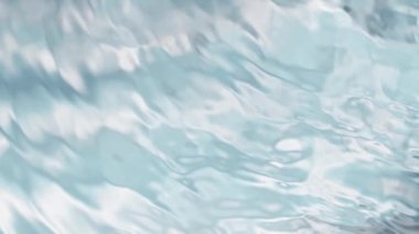 Açık mavi arkaplanda yavaş su sıçratma, yüksek hızlı sinematik kamera 1000 FPS