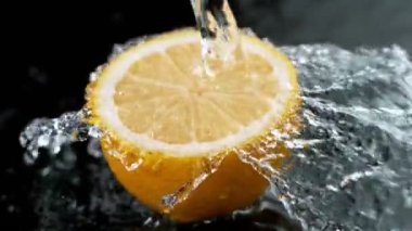 Su Sıçratarak Limon Diliminin Süper Yavaş Hareketi. Kara Arkaplan 'da izole edilmiş. Yüksek Hız Sinema Kamerası, 1000 Fps