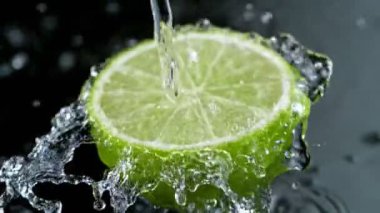 Su Sıçratan Limon Diliminin Süper Yavaş Hareketi. Kara Arkaplan 'da izole edilmiş. Yüksek Hız Sinema Kamerası, 1000 Fps