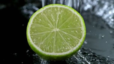Su Sıçratan Limon Diliminin Süper Yavaş Hareketi. Kara Arkaplan 'da izole edilmiş. Yüksek Hız Sinema Kamerası, 1000 Fps