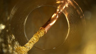 Birayı bardaktan bardağa doldurma hareketi donuyor. Bardağın altından benzersiz bir bakış açısı .