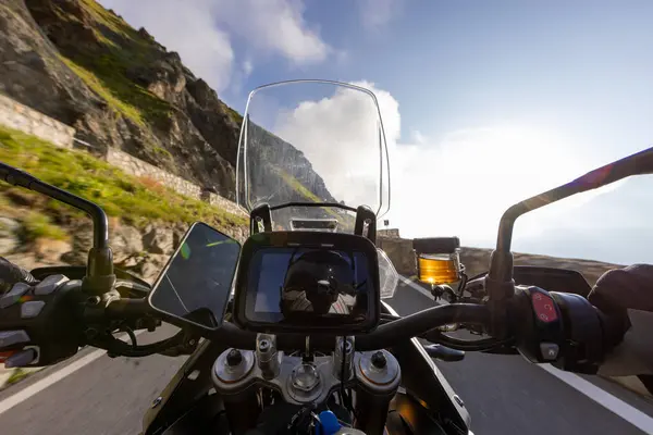 stock image Motorbiker riding in Italian Alps during sunrise, dramatic sky. Travel and freedom, outdoor activities