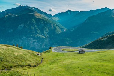 Motorbiker riding in Italian Alps during sunrise, dramatic sky. Travel and freedom, outdoor activities clipart