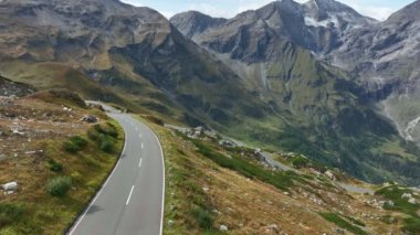 Sakin Avusturya dağlarında asfalt bir yolda motosikletler ve arabalar dolaşır. Görkemli Kayalık Alpler .