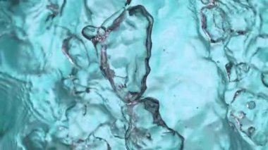 Açık mavi arkaplanda yavaş su sıçratma, yüksek hızlı sinematik kamera 1000 FPS