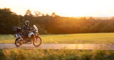 Gün batımında boş yolda motosiklet sürüyorum.