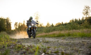 Gün batımında boş yolda motosiklet sürüyorum.