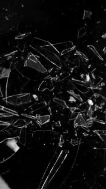 Siyah arkaplana karşı kırılan camın süper yavaş hareketi, dikey yönelim. Yüksek hızlı sinema kamerası, 1000 fps..