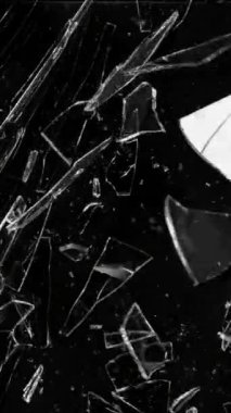 Siyah arkaplana karşı kırılan camın süper yavaş hareketi, dikey yönelim. Yüksek hızlı sinema kamerası, 1000 fps..