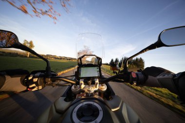 Gün batımında motosiklet sürmek, gidon manzarası, sonbahar dağları.