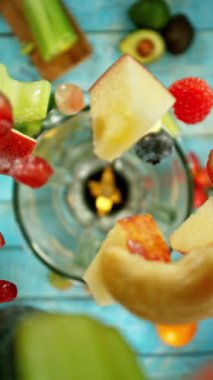 Taze meyve ve sebzeli smoothie blender ile harmanlanmış, üst manzara. Sağlıklı beslenme konsepti. Süper yavaş çekim, yüksek hızlı sinematik kamerayla çekildi..