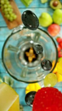 Taze meyve ve sebzeli smoothie blender ile harmanlanmış, üst manzara. Sağlıklı beslenme konsepti. Süper yavaş çekim, yüksek hızlı sinematik kamerayla çekildi..