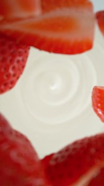 Çileklerin kremaya dökülmesi süper yavaş bir hareket. Hareketli ve dönüşlü yüksek hızlı sinema kamerası ile çekildi, 1000fps.