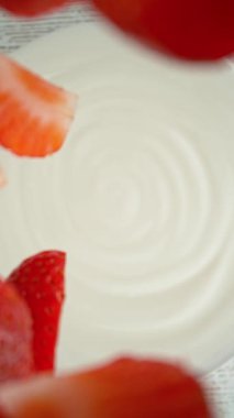 Çileklerin kremaya dökülmesi süper yavaş bir hareket. Hareketli ve dönüşlü yüksek hızlı sinema kamerası ile çekildi, 1000fps.