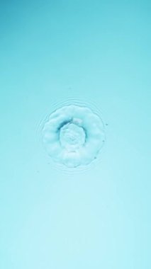 Açık mavi arkaplanda yavaş su sıçratma hareketi, yüksek hızlı sinematik kamerada 1000 FPS 'de çekilmiştir.