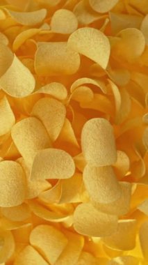 Patates cipslerinin gradyan sarı arka planda çok yavaş hareket etmesi. Yüksek hızlı sinema kamerası, 1000 fps..