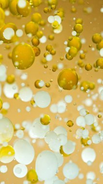 Moving Oil ve Süt Kabarcıklarının Altın Arkaplanda Macro Çekimi, Kozmetik Konsepti