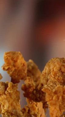 Süper yavaş çekimde uçan lezzetli tavuk parçaları ve kamera hareketi. Yüksek hızlı sinema kamerası, 1000 fps..