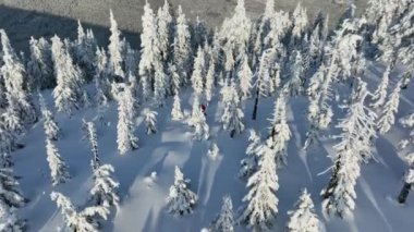 Kışın dağları aşan kayak yapan adamın hava manzarası, taze kar..