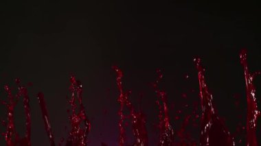 Koyu arka planda dans eden kan damlaları çok yavaş hareket ediyor. Yüksek hızlı sinema kamerası, 1000fps