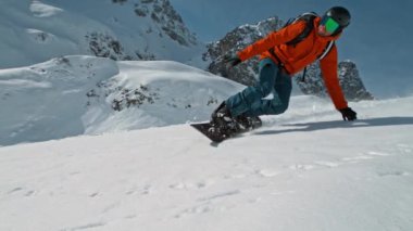 Güneşli bir günde kar kaykayı sürücüsü taze toz altında, Alp manzaralı. 1000 fp 'de süper yavaş çekim..
