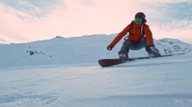 Güneşli bir günde kar kaykayı sürücüsü taze toz altında, Alp manzaralı. 1000 fp 'de süper yavaş çekim..