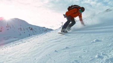 Güneşli bir günde kar kaykayı sürücüsü taze toz altında, Alp manzaralı. 1000 fp 'de süper yavaş çekim..