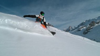 Güneşli bir günde kar kaykayı sürücüsü taze toz altında, Alp manzaralı. 1000 fp 'de süper yavaş çekim..