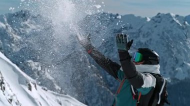 Güneşli bir günde İtalyan Dolomitlerine kar atan bir kayakçı. 1000 fp 'de süper yavaş çekim. .
