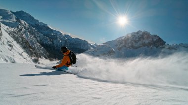Manzaralı Alp dağlarında kayakçı. Taze toz kar içinde. Güneşli güzel bir gün.