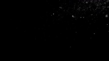 Siyah zemin üzerinde izole edilmiş toz parçacıkları uçuşuyor. Yüksek hızlı kamera, 1000 fps.