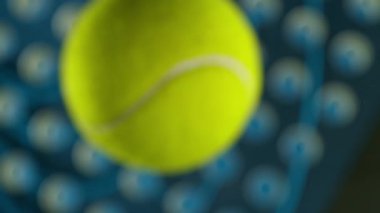 Padel raket ve top siyah arka plana çarptı. Yüksek Hız Sineması Kamerası 'nda 1.000 fps hızla çekilmiştir.
