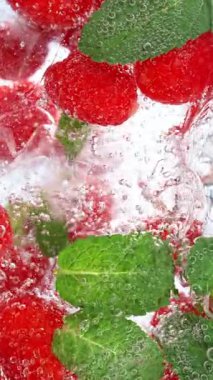 Buz küpleri ve meyvelerle bardağa maden suyu dökme hareketi. Yüksek Hız Sinema Kamerası, 1000fps