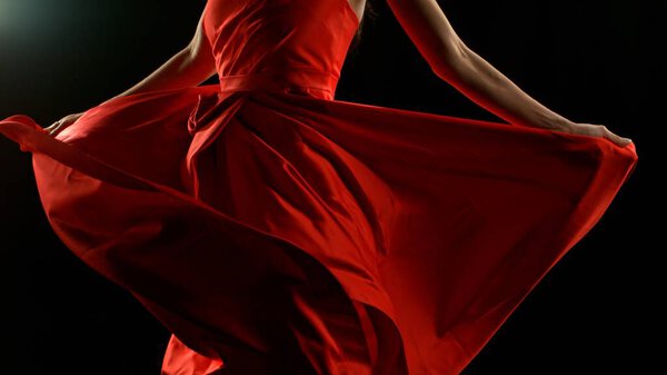 Brunette Woman in Ruby Red Dress Dancing Against a Black Background , Freeze Motion
