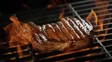 Slow Motion of Beef Steak on a Grill with Roaring Flames , Camera Move . 1000 FPS 'te Yüksek Hız Sineması Kamerası' nda çekildi. .