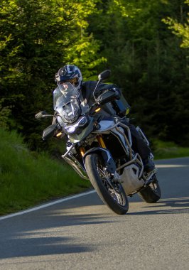 Boş asfalt yolda motosiklet süren sürücü, bulanık motivasyon, bahar dağları