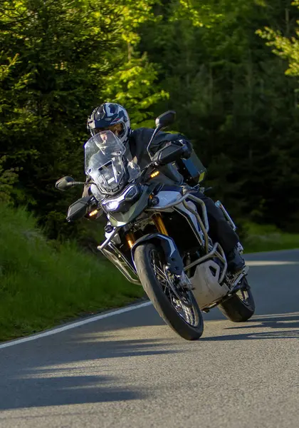 Boş asfalt yolda motosiklet süren sürücü, bulanık motivasyon, bahar dağları