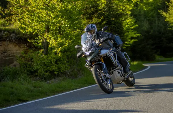 Boş asfalt yolda motosiklet süren sürücü, bulanık motivasyon, bahar dağları