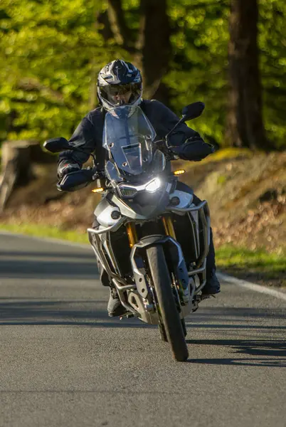 Boş asfalt yolda motosiklet süren sürücü, bulanık motivasyon, bahar dağları